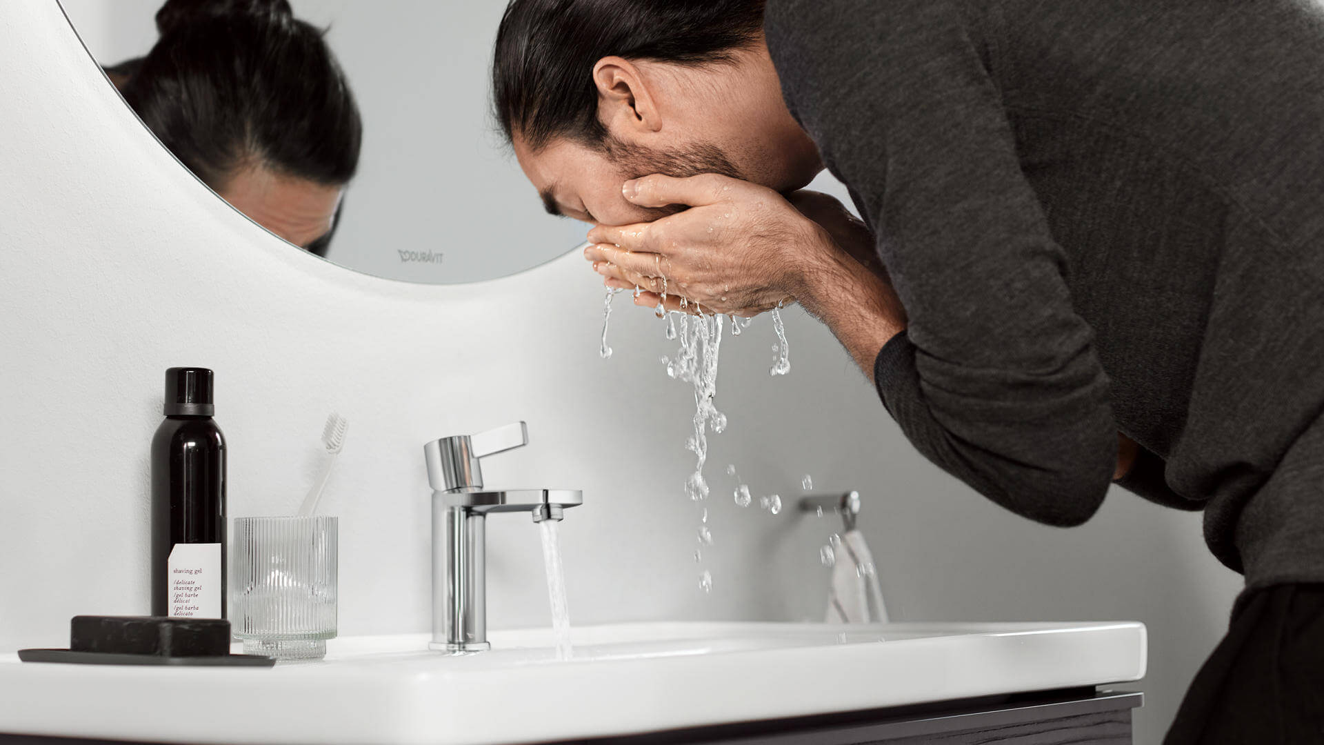 Uomo che si lava il viso di fronte a rubinetto D-Neo