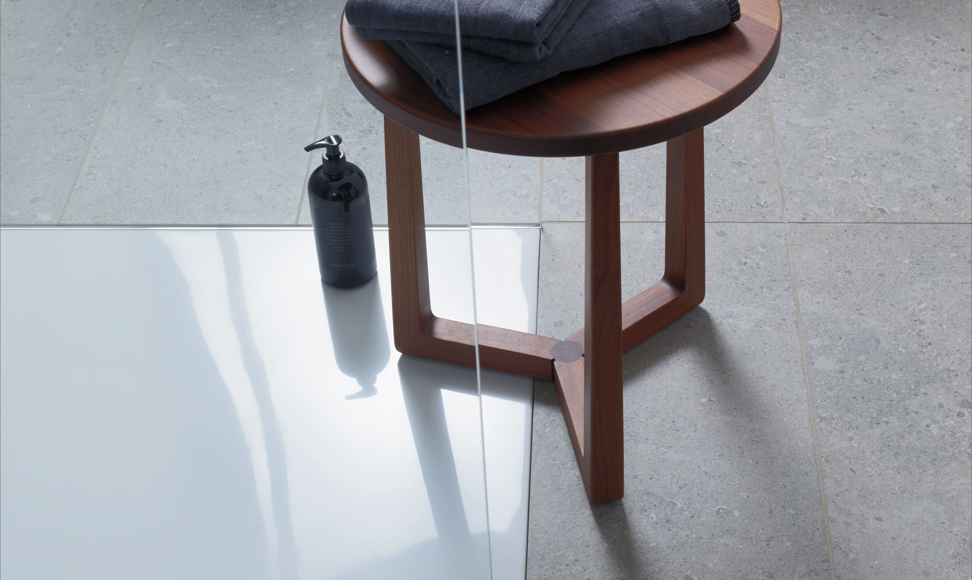 Stool stands on shower tray at floor-level
